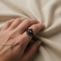 Ring mit dunkellila Tropfenstein und Ornamenten