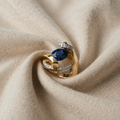 Ring goldfarben mit ovalem blauen Kristall