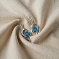 Ohrringe mit silberfarbenem Herz und blauem Kristall